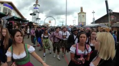 Kamera, Oktoberfest festivalinin merkez caddesindeki Kalabalık 'tan hareket ediyor. Bavyera, Almanya