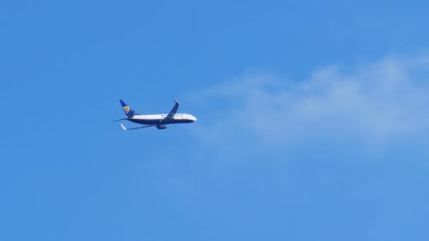 El avión de pasajeros vuela lejos en el cielo azul — Vídeos de Stock