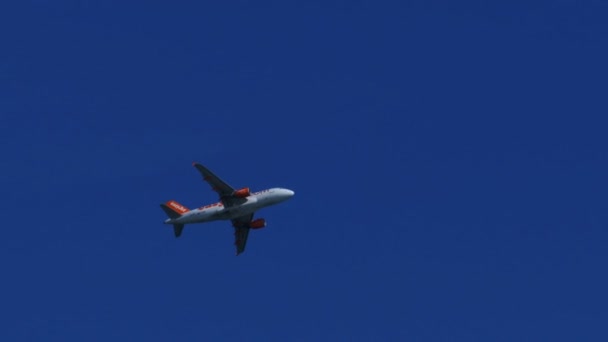 El avión de pasajeros vuela lejos en el cielo azul — Vídeos de Stock