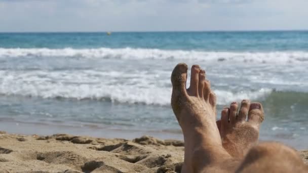 Pernas do homem deitado na praia perto do mar, POV — Vídeo de Stock