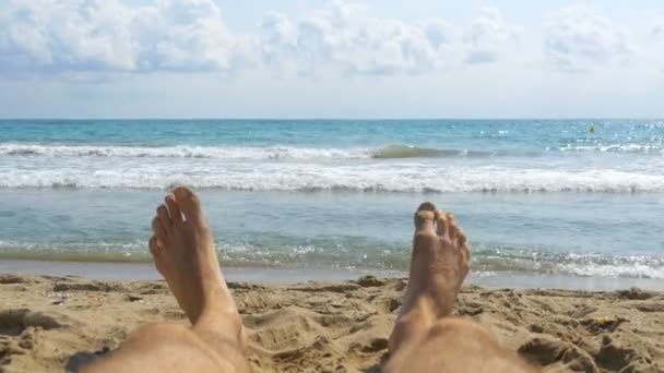 Lába az ember feküdt, strandon, a tenger közelében, a Pov — Stock videók