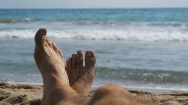 Erkekler yalan Pov denize sıfır plaj üzerinde bacakları. Ağır çekim