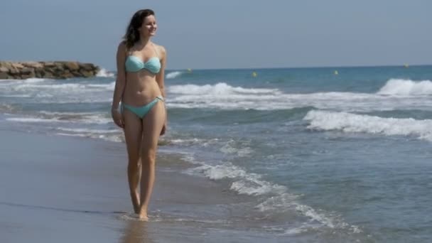 Chica joven camina a lo largo de la playa de la costa del mar en cámara lenta — Vídeo de stock