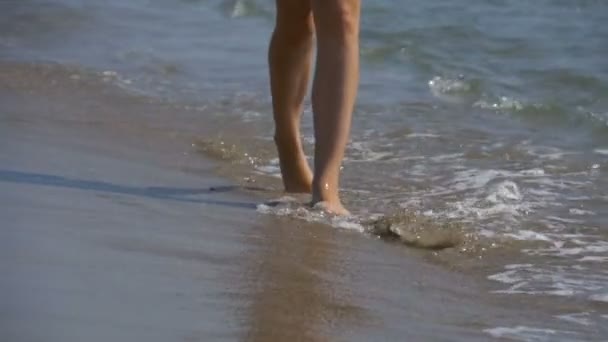 Chica joven camina a lo largo de la playa de la costa del mar en cámara lenta — Vídeo de stock