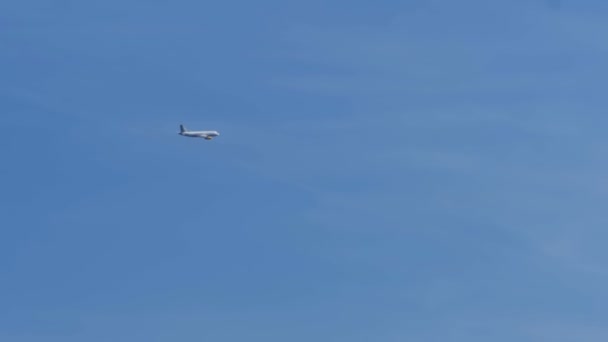 El avión vuela lejos en el cielo azul. Moción lenta — Vídeo de stock