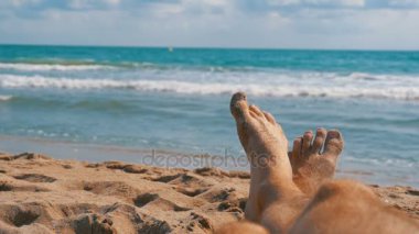 Erkekler yalan Pov denize sıfır plaj üzerinde bacakları. Ağır çekim