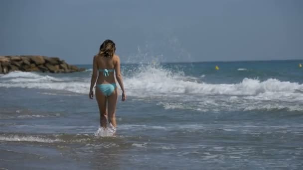 Девушка в купальнике бежит вдоль берега моря на пляже в Slow Motion — стоковое видео