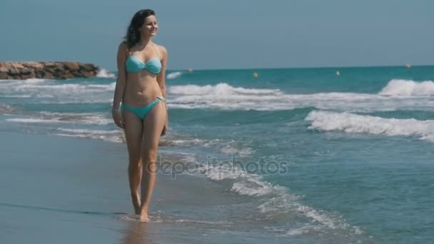 Chica en traje de baño corre a lo largo de la orilla del mar en la playa en cámara lenta — Vídeos de Stock