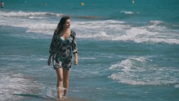 Chica joven camina a lo largo de la playa de la costa del mar en cámara lenta — Vídeos de Stock