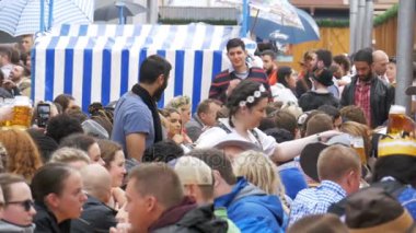 Masadaki sarhoş insanların sokakta bir büyük bira çadırda Oktoberfest kutlamak. Bavaria, ağır çekim