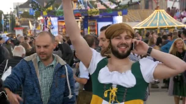 Homem bêbado em uma rua vestido com um dirndl feminino está se divertindo no Oktoberfest. Baviera — Vídeo de Stock