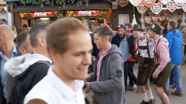 La gente en trajes nacionales bávaros se divierten en la calle de Oktoberfest. Baviera, cámara lenta — Vídeos de Stock