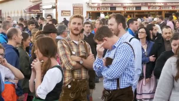 Menschen in bayrischen Trachten auf der Straße des Oktoberfests. Bayern, Zeitlupe