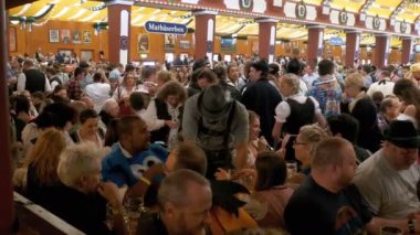 Masadaki sarhoş insanların bir büyük bira çadırına Oktoberfest kutlamak. Bavyera, Almanya