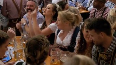 Masadaki sarhoş insanların bir büyük bira çadırına Oktoberfest kutlamak. Bavyera, Almanya