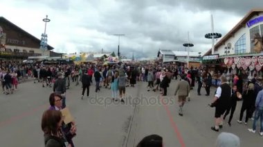 Kamera, Oktoberfest festivalinin merkez caddesindeki Kalabalık 'tan hareket ediyor. Bavyera, Almanya
