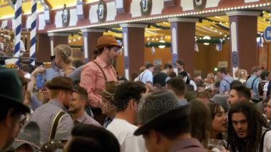 İnsanlar kutlama Oktoberfest büyük bira çadırda. Bavyera, Almanya