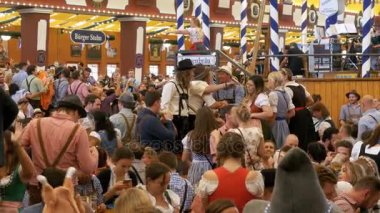 Masadaki sarhoş insanların bir büyük bira çadırına Oktoberfest kutlamak. Bavyera, Almanya