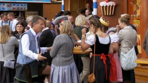 Mensen lopen langs de centrale straat van het Oktoberfest festival. Beieren, Duitsland — Stockvideo