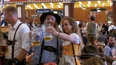 Sarhoş kadın ve adam ile bir kupa bira Oktoberfest bir büyük bira çadırına kutluyor. Bavyera, Almanya