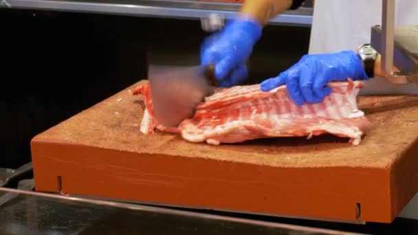 屠夫在 La Boqueria 的市场上用刀子切割牛肉排骨的生肉。巴塞罗那.西班牙 — 图库视频影像