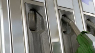 Eski bir benzin istasyonunda yakıt püskürtme uçlarını kullanarak kadın ele. Akaryakıt istasyonu. Yanacaq-doldurma məntəqələri.