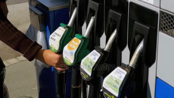 Mano de mujer usando boquillas de combustible en una gasolinera. Estación de llenado. Gasolinera . — Vídeo de stock