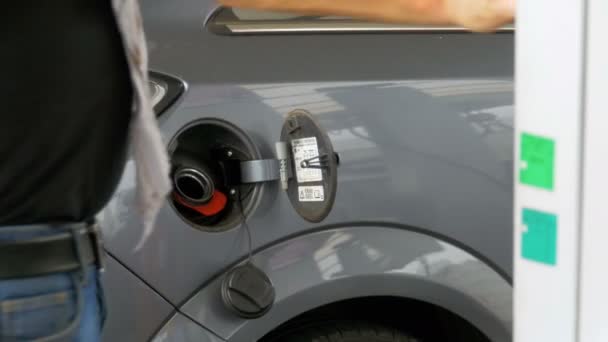 Чоловік заповнює автомобіль дизельним паливом. Чоловік використовує бензиновий насос, щоб заповнити машину паливом . — стокове відео
