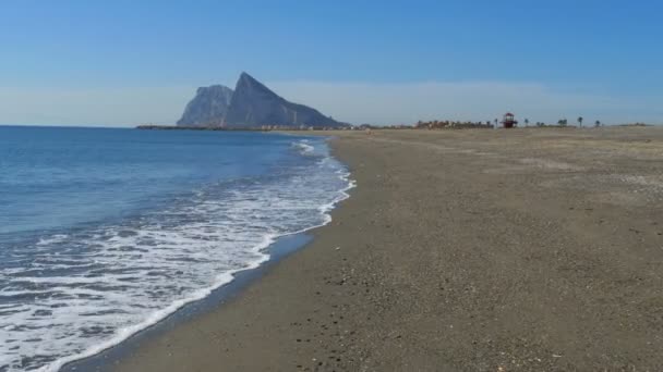 Blick auf den Felsen von Gibraltar und den Strand mit Meereswellen — Stockvideo