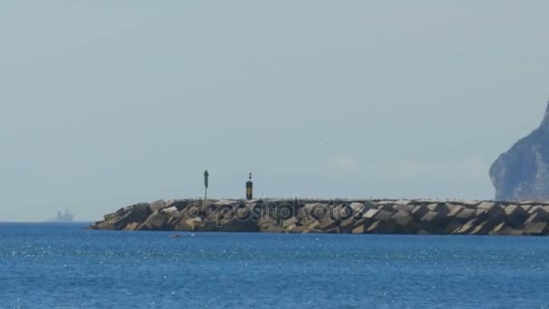 Utsikt över fyren vid havet nära den klippa av Gibraltar. Spanien. — Stockvideo