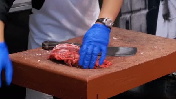 Carniceiro cortando carne crua com faca grande no mercado de La Boqueria. Barcelona. Espanha — Vídeo de Stock