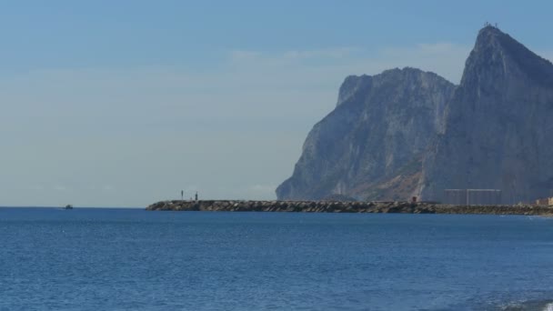 Zicht op de vuurtoren door de zee in de buurt van de rots van Gibraltar. Spanje. — Stockvideo