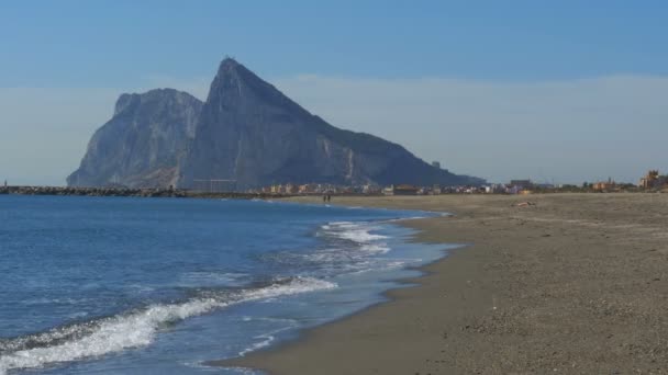 Vista del Peñón de Gibraltar y la playa con olas marinas — Vídeo de stock