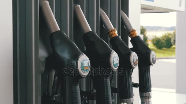 Mano de mujer usando boquillas de combustible en una gasolinera. Estación de llenado. Gasolinera . — Vídeo de stock