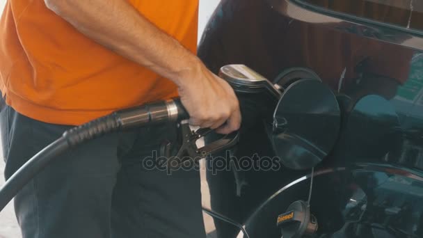 Un homme remplissant sa voiture d'essence. Mans main en utilisant une pompe à essence pour remplir sa voiture avec du carburant . — Video