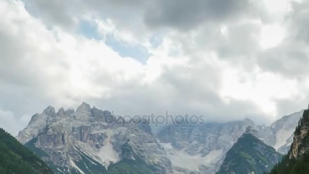 Nuvens estão se movendo sobre os picos das montanhas alpinas e um lago de montanha. Prazo de validade — Vídeo de Stock