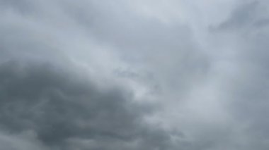 Gri yağmur bulutları gökyüzünde hareket ediyor. Timelapse