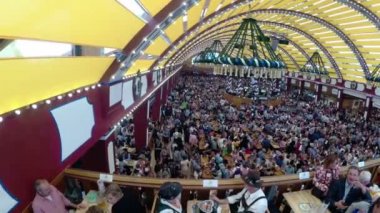İnsanlar kutlama Oktoberfest büyük bira çadırda. Bavyera, Almanya