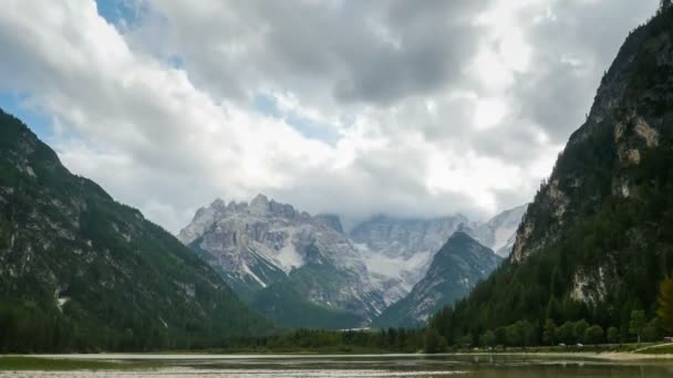Las nubes se mueven sobre los picos de las montañas alpinas y un lago de montaña. Tiempo de caducidad — Vídeo de stock