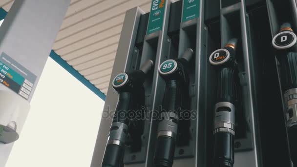 Verschillende benzine pistool bij een benzinepost. Gas brandstof pomp mondstuk. — Stockvideo