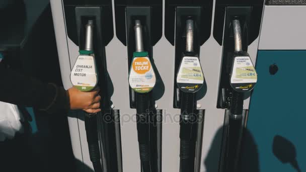 Mano de mujer usando boquillas de combustible en una gasolinera. Estación de llenado. Gasolinera . — Vídeo de stock