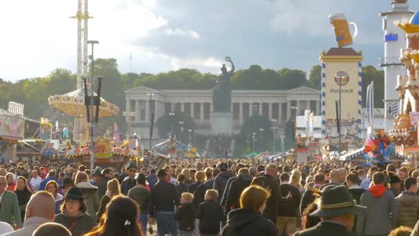 人々 の群衆は、オクトーバーフェストの中央通りに沿って歩いています。ドイツ、バイエルン州 — ストック動画