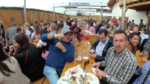 Részeg ember az asztalnál Oktoberfest ünnepelni egy nagy söröző az utcán. Bavaria, Németország — Stock videók