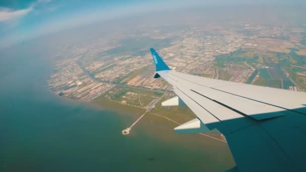 Vista da janela de um avião a jato voando baixo sobre a cidade . — Vídeo de Stock