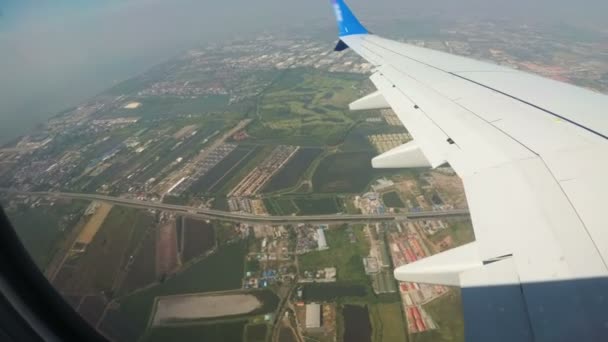 Blick aus dem Fenster eines Düsenflugzeugs im Tiefflug über der Stadt. — Stockvideo