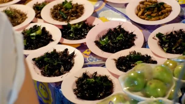 在夜间食品市场上的盘子里有不同种类的熟昆虫。亚洲, 泰国, 芭堤雅 — 图库视频影像