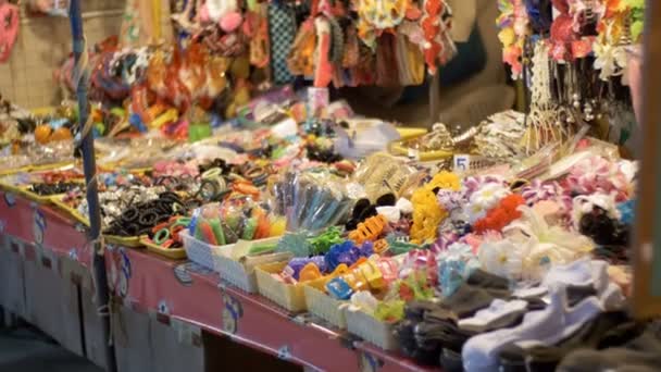 Escaparate con una variedad de pequeños productos en el mercado nocturno de Jomtien. Tailandia. Pattaya — Vídeos de Stock