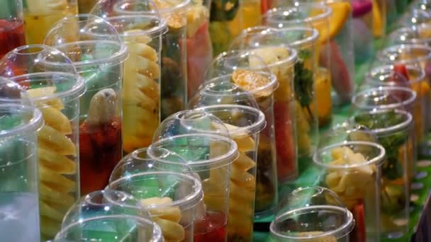 Vitrine met vruchten in plastic bekers op de avondmarkt op Jomtien Beach. Pattaya, Thailand — Stockvideo