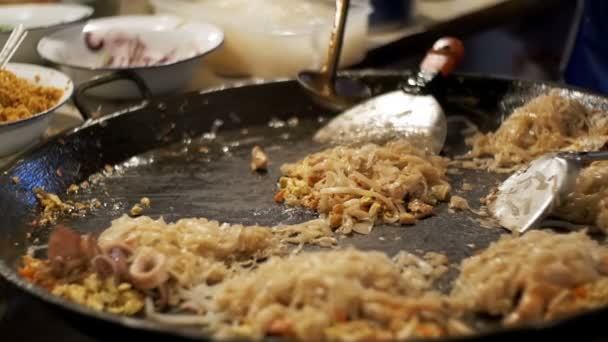亚洲街头美食。海鲜, 米粉用鸡蛋煮在一个大煎锅上。慢动作。泰国 — 图库视频影像
