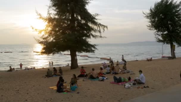 Mensen rusten op het tropische strand bij zonsondergang. Pattaya, Thailand — Stockvideo